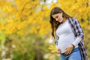 donna in gravidanza in un parco d'autunno