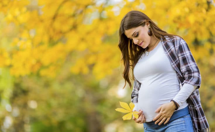 donna in gravidanza in un parco d'autunno